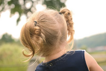 girl wearing blue sleeveless top with ponytail hair outdoors thumbnail