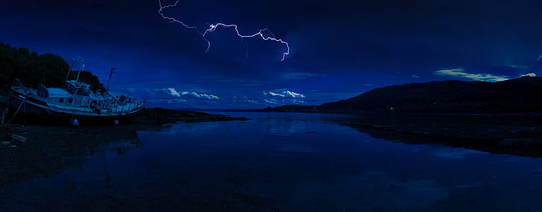 white and brown sailboat near body of water during night time thumbnail