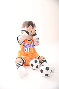 baby wearing soccer jersey holding his headband with soccer balls thumbnail