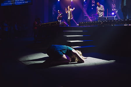 person kneeling in front of concert stage thumbnail