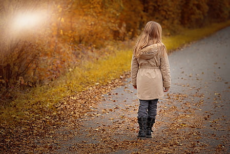 girl wearing beige coat and black boots on road thumbnail