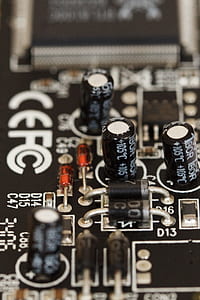 selective focus photography of brown motherboard with four capacitors thumbnail