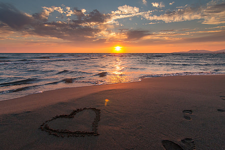 heart written on beach sand during golden hour thumbnail