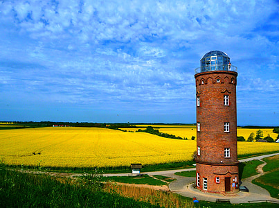 brown concrete tower near field under blue sky and white clouds during daytime thumbnail