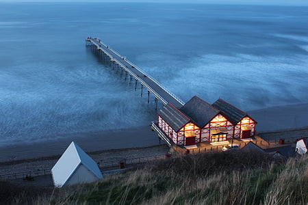 brown and black building beside wooden dock thumbnail
