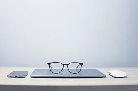 black framed eyeglasses on top of laptop thumbnail