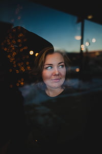 woman standing near window with bokeh light reflection thumbnail