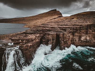 photo of brown mountain near body of water thumbnail