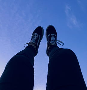 Person Wearing Vans Old Skool Sneakers Raising His Feet Pointing to They Sky thumbnail