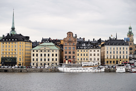 gray and white concrete buildings near body of water thumbnail