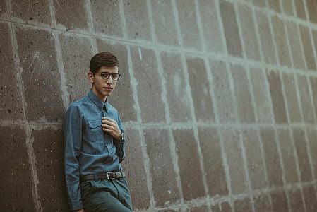 man standing in front of brown wall thumbnail