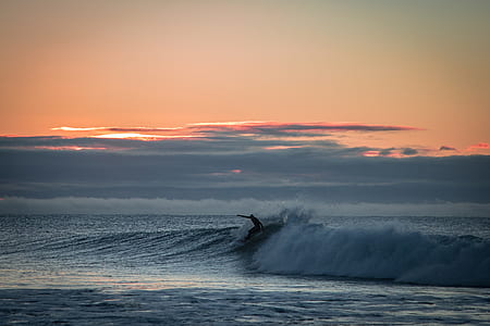 silhouette of man surfing man at the sea during golden hour thumbnail