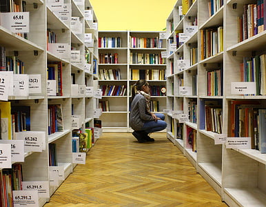 woman in gray sweater near book lot on beige cubby shelf thumbnail
