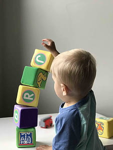 boy holding top of building blocks thumbnail