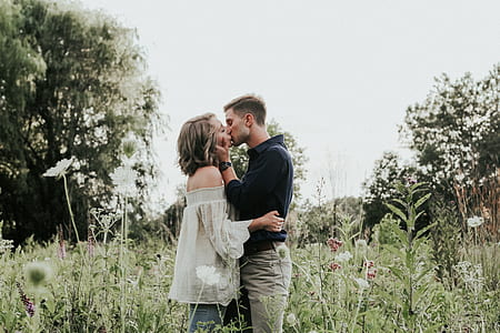 woman and man kissing near plants and trees thumbnail