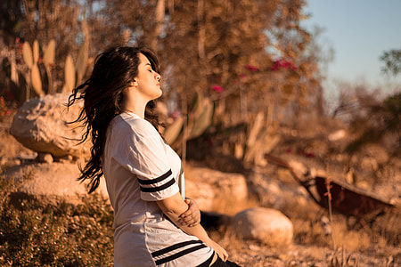 woman sitting near brown rocks thumbnail