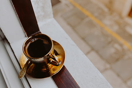 Drink coffee in a golden cup at the window thumbnail