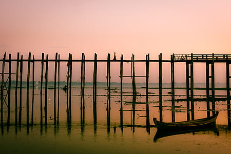 black boat beside a wooden bridge thumbnail