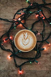top view of mug filled with coffee latte surrounded by string lights thumbnail