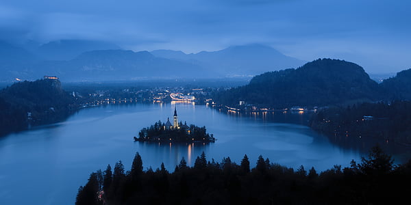 light tower surrounded by body of water during nighttime thumbnail