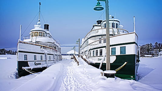 two white-and-black ships near post thumbnail