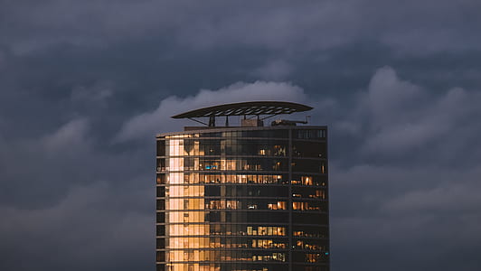 worms eye view of gray concrete building under cloudy sky thumbnail