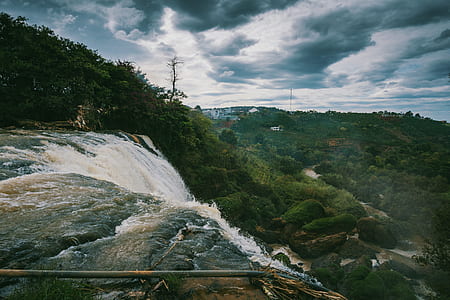 Waterfalls Beside Green High Trees Under White Sky at Daytime thumbnail