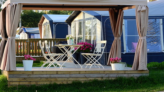 brown canopy tent with white metal 2-piece patio set underneath at daytime thumbnail