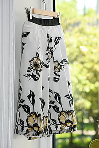 shallow focus photo of white, black, and yellow floral skirt hanging thumbnail