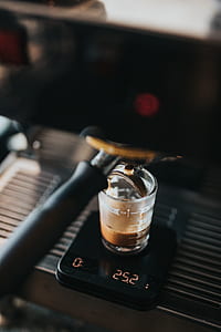 selective focus photography of clear glass with brown liquid inside on black digital scale displaying 25.2 thumbnail