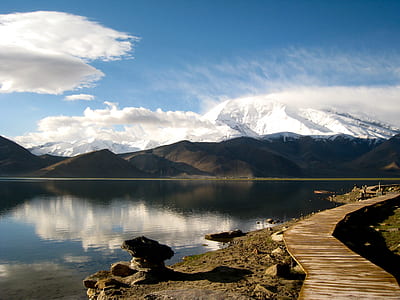 lake and mountain under blue sky with white clouds view during daytime thumbnail