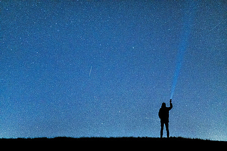 man standing point flashlight thumbnail
