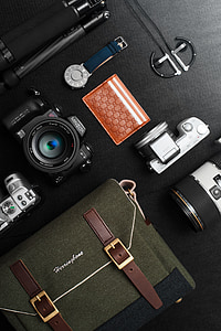 black Minolta DSLR camera beside bag on table thumbnail