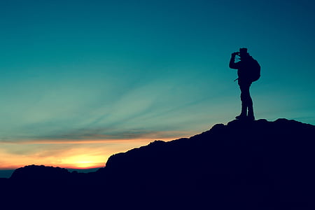 silhouette on man with backpack on mountain peak during golden house thumbnail