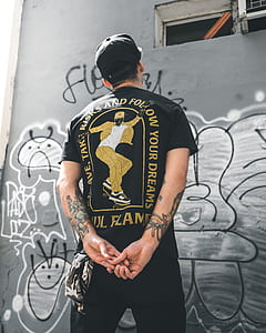 man looking at window of building with mural thumbnail