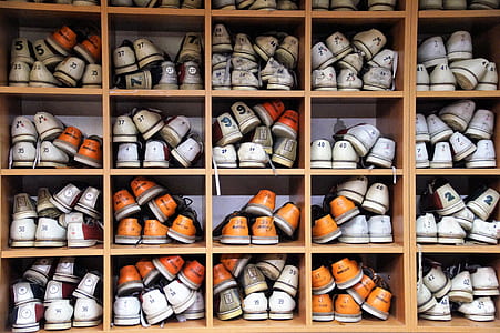 sneaker lot on brown wooden shoe rack thumbnail