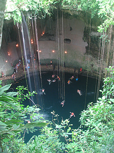 people swimming on body of water near cliff thumbnail