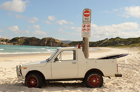 white single cab pickup truck parked beside brown pole with signboards thumbnail