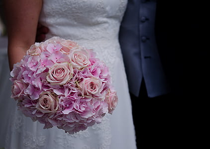 woman in white dress holding pink and peach bouquet of flower thumbnail