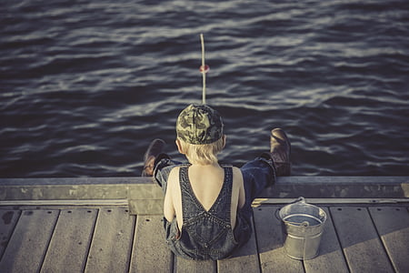 boy's wearing fishing wader sitting on the brown dock thumbnail