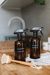 two brown spray bottles beside brown brush thumbnail