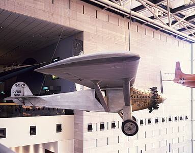 gray and brown biplane near building thumbnail