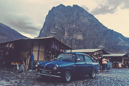 classic blue coupe parked beside wooden house thumbnail