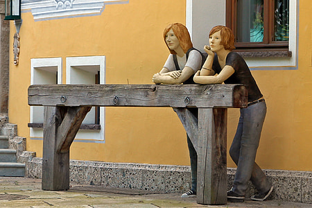 two ceramic statutes standing beside wooden stands thumbnail