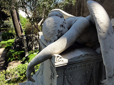 lying angel statue beside green leaf trees at daytime thumbnail