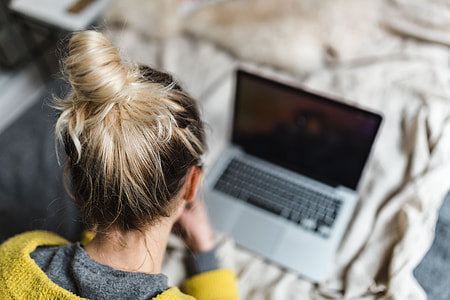 Blond using her laptop at her bedroom thumbnail