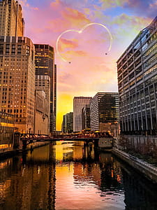Two Black Aircrafts Above Buildings Golden Hour thumbnail