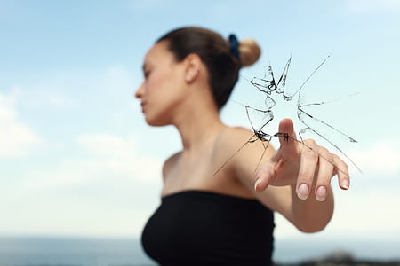 woman in black tube top holding broken glass thumbnail
