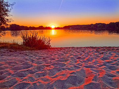 body of water near green plants during golden hour thumbnail