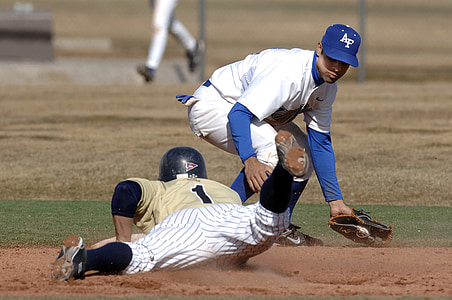 baseball player sliding to base plate beside another baseball player thumbnail